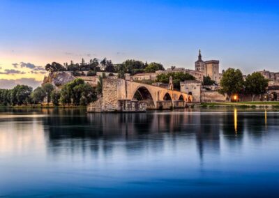 The avignon bridge on the rhone river photographed at dusk to highlight options of vacations in france.