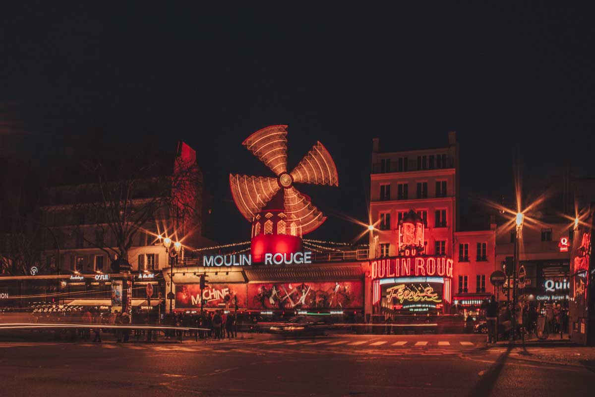 An images of the moulin rouge in paris at night, used to illustrate vacations in france from turas travel
