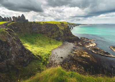 the northern ireland coastline and the ruins of dunluce castle illustrating some of the options of vacations in ireland